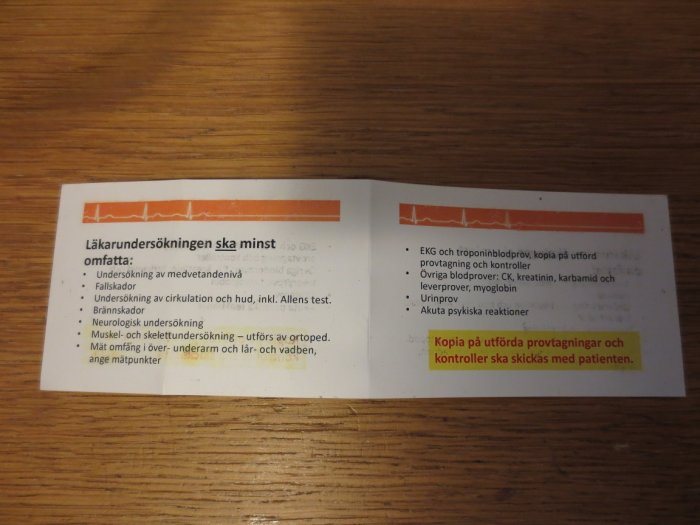 Öppnat fyrsidigt häfte i kontokortsformat med text om läkarundersökningar, ligger på ett bord.