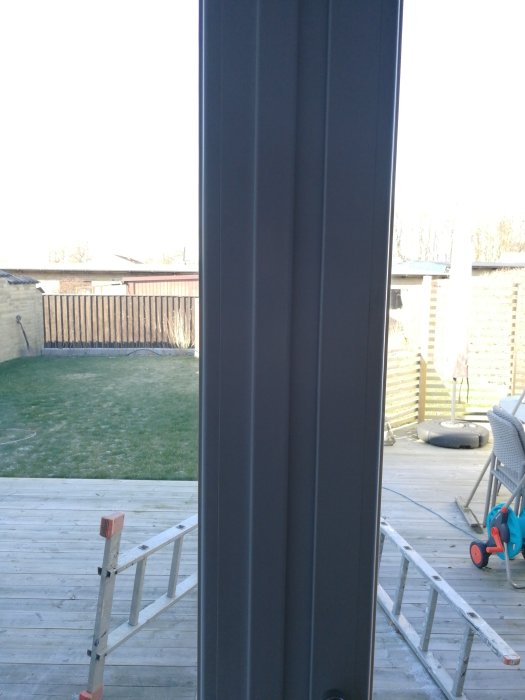 Bild på dörrkarm utan synlig kopplingslist, utsikt mot altan och trädgård.