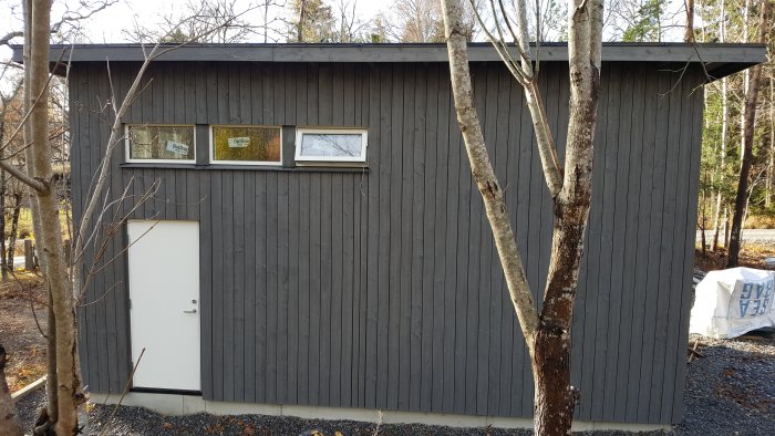 Ett hus med liggande träpanel målat i grått med hjälp av tjärvitriol, som ger ett åldrande skydd och gråare kulör över tid.