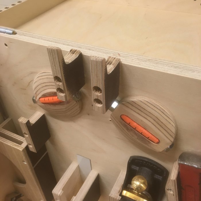 Trädetaljer med runda pluggar och fläns monterade på en plywoodplatta som del i ett byggprojekt.
