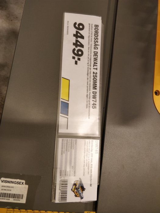 Prislapp för en DEWALT bordsåg modell DW745 på 9 449 kronor vid K-rauta med visningsetikett.