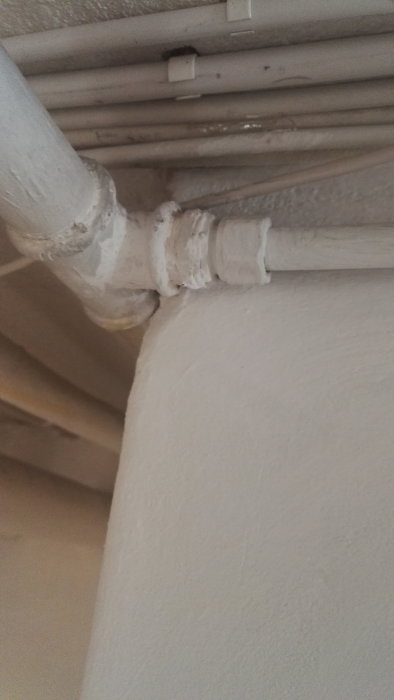 Rörinstallation med en äldre t-koppling till ett stålrör skarvat till ett kopparrör.