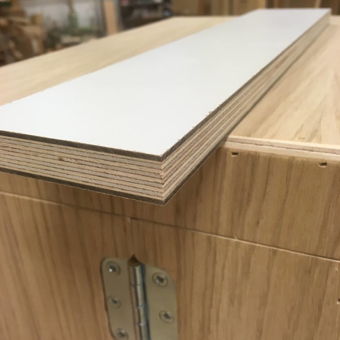 Närbild på laminerade björkplywoodskivor och en del av en hyvelbänksprototyp.