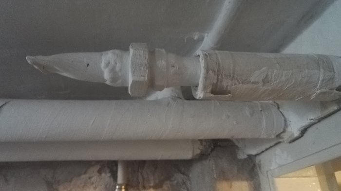 Äldre rörinstallation med isolerade rör och synliga kopplingar under ett tak, föreslagen för pluggning.