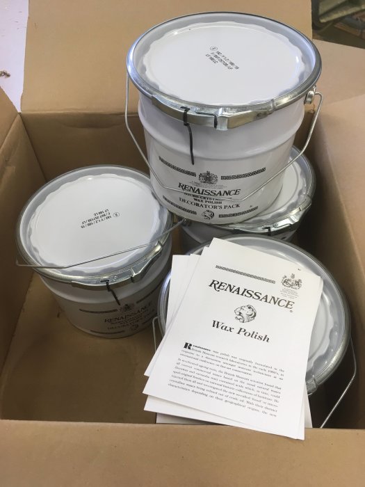 Flera burkar med Renaissance Wax Polish i en kartong tillsammans med produktinformation.