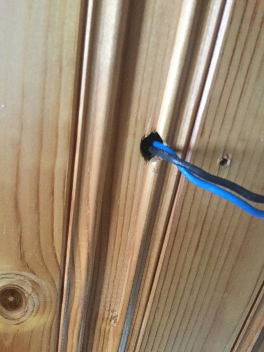 Kabel som sticker ut från ett VP-rör i ett träpaneltak.