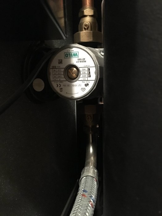 Värmepump med detaljbild på cirkulationspump och röranslutningar i ett hemmabyggprojekt.