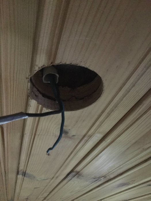 Ett 67mm öppet hål i ett träbeklätt tak med synliga elledningar.