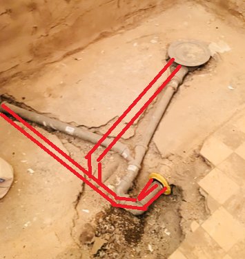 VVS-installation med synliga rör och föreslagen ny rördragning markerad med röda linjer i ett betonggolv.