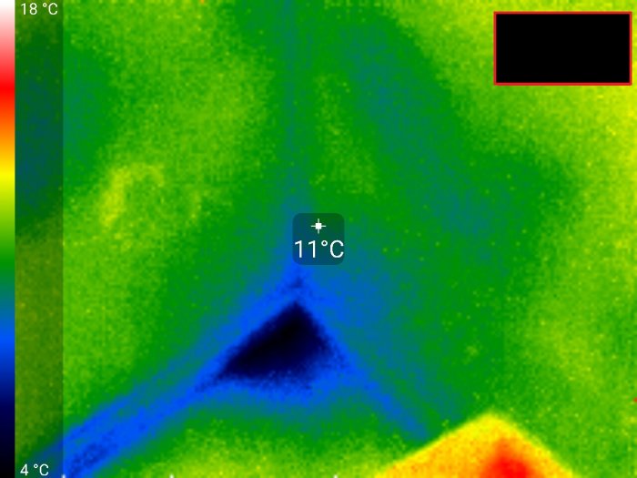 Värmekamera visar kallare hörn i rum med temperaturangivelse på 11°C i blå nyans mot en varmare grön-gul bakgrund.