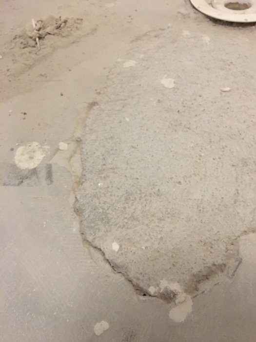 Gjutmassa som inte sitter fast vid betongunderlag i en pågående renovering.