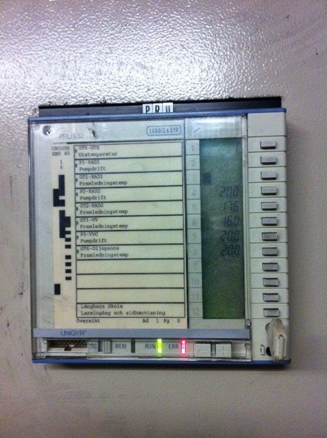 Äldre programmerbar termostat eller regulator monterad på vägg, med numerisk display och knappsats.