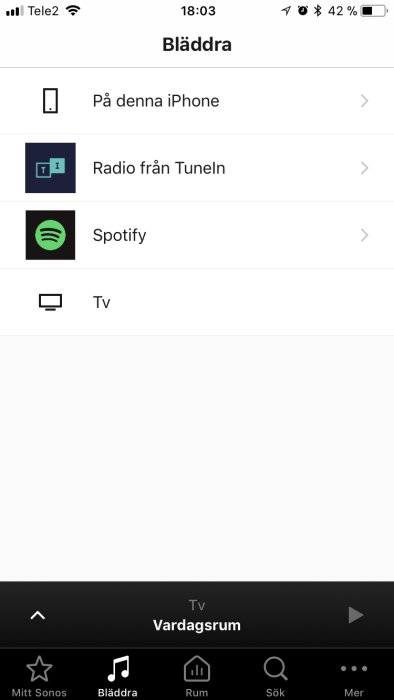 Skärmdump av iPhone musikspelare med menyn 'Bläddra', lokala och streaming alternativ såsom Spotify.
