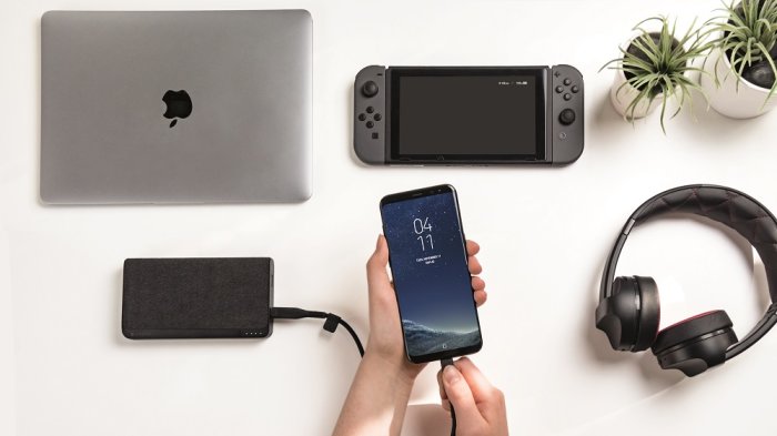 Bord med gadgetar inklusive en laptop, spelkonsol, plantor, hörlurar och en mobil laddad med Mophie powerbank.