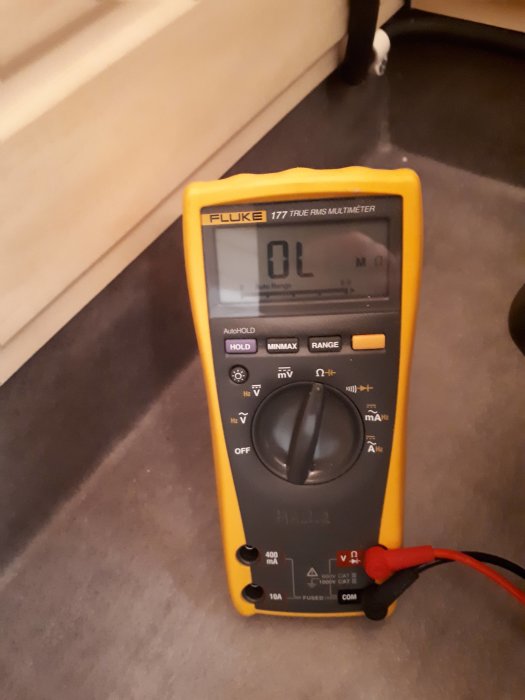 En digital multimeter visar "OL" på skärmen vilket indikerar öppen krets eller överbelastning.