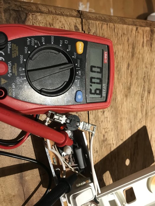 Multimeter visar ett värde på 6.61 med testledningar anslutna till en elektrisk komponent.