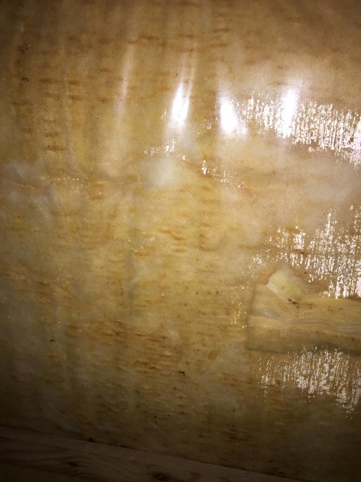 Blöt isolering och sprucken plastfilm på kallvind i 1970-talets hus, tecken på fuktskador och mögel.