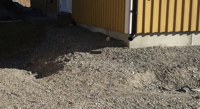 Hög med bergkross runt husgrund, ifrågasatt för möjlig borttagning vid trallbygge.