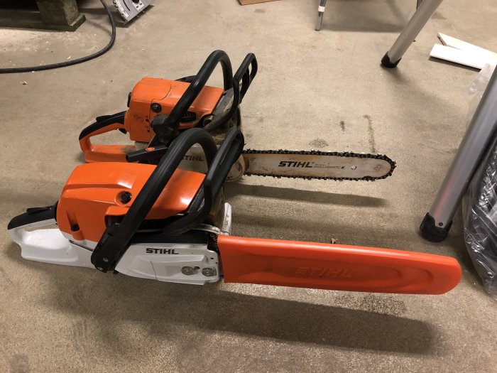 Två Stihl motorsågar på ett garagegolv, en äldre och en nyare modell MS261.