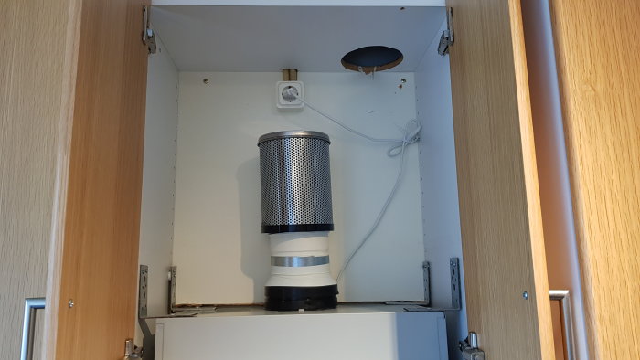 Köksskåp med installerad kolfilterfläkt, synlig elkontakt och otillräcklig ventilation.