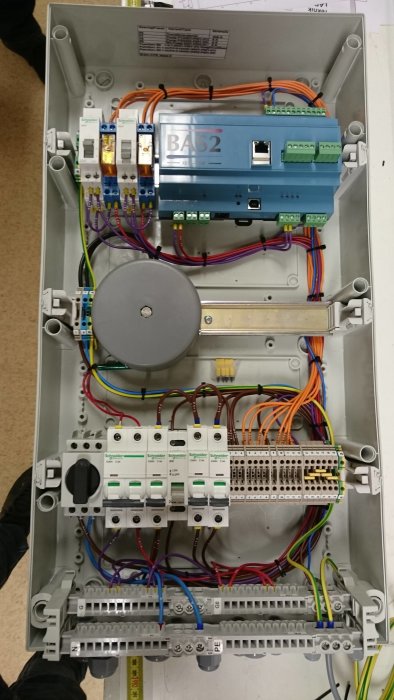 Elektriskt skåp med organiserad kabeldragning och märkta hylsor för stadiga och säkra anslutningar.