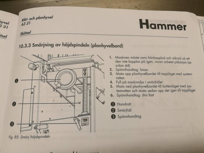 Illustration av smörjprocessen för höjdspindeln på en planhyvel med markerade delar som smörjhål.