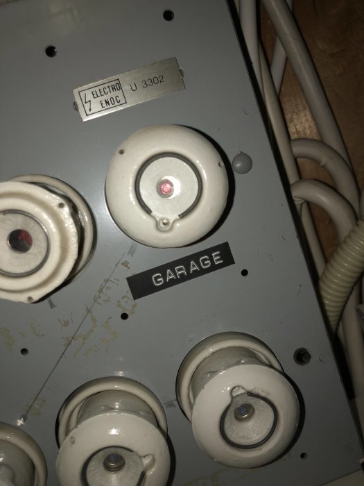 Elcentral med gamla proppar och en etikett märkt ”GARAGE”, säkring på 10A synlig.