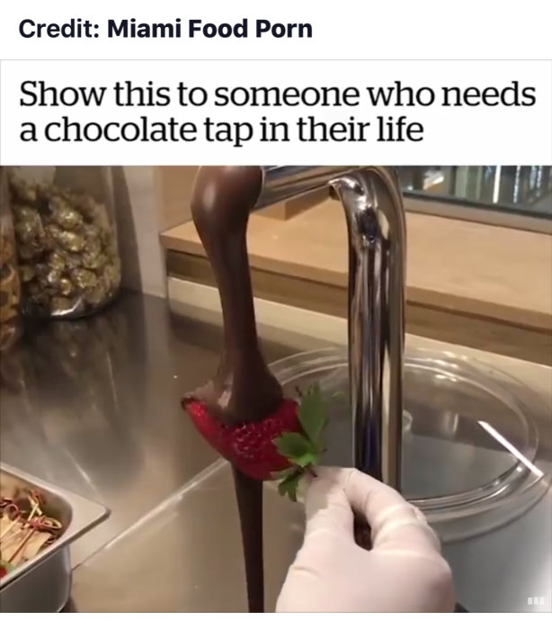 En hand med vit handske håller en jordgubbe under en kran som helt otippat visar sig servera flytande choklad istället för vatten.