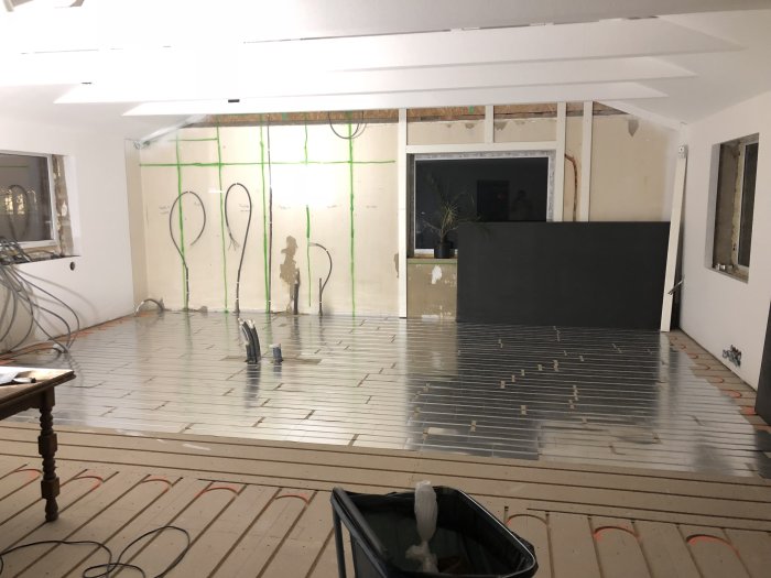 Installation av golvvärmeplåtar och slangrör för golvvärme i ett under renovering hus.