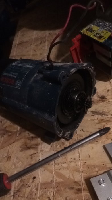 Elektrisk motor öppnad visar inre delar och potentiellt lagerhaveri på arbetsbänk.
