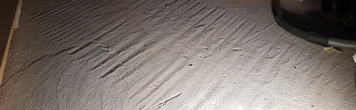Ojämn gjuten betongplatta med spår och oregelbundet mönster, behov av flytspackling diskuteras.