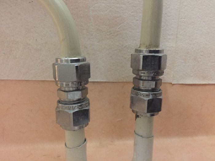 Rör med klämringskopplingar märkta R15 och R20 som är en del av en badrumsrenovering.