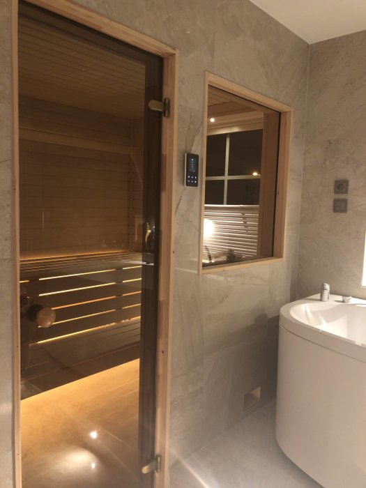 Ett modernt badrum med bubbelbadkar och bastu, förberett för TV-installation.