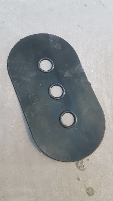 Svart LK tätmanchett med utlopp för tre rör på betonggolv, avsedd för användning med tätskikt.
