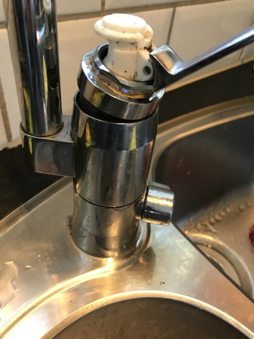 Närbild på en Mora köksblandare med en trög blandararm och en synlig vit plastinsats, monterad över en diskho.