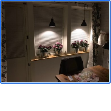 Tillfällig belysning med sladdar som går upp bakom gardin, Eurokontaktdosa synlig under fönster.