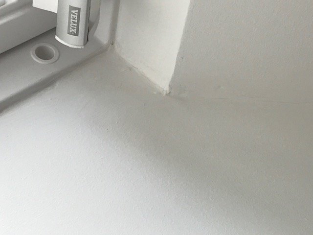 Dåligt utfört målningsarbete i ett hörn vid en entré som blivit underkänt av besiktningsman.