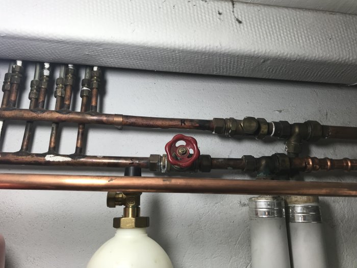 Kopparledningar och ventiler på en vägg i ett pannrum.