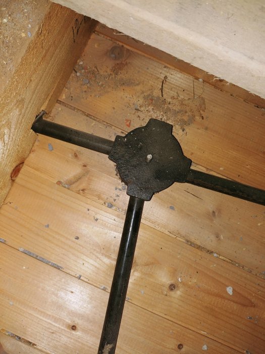 Synligt metallrör för elinstallation genom träbjälklag vid renovring av 40-talshus.