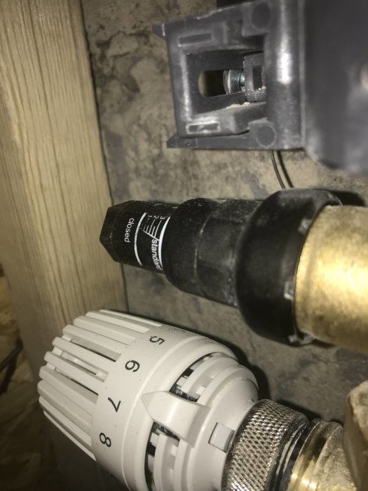 Termostatventil på radiator inställd på strax över 3 med synlig returventil och röranslutning.