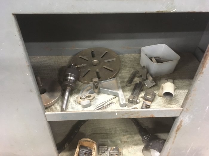 Delar till Myford Super 7B, koppling och verktyg i en metallhylla, redo för försäljning.