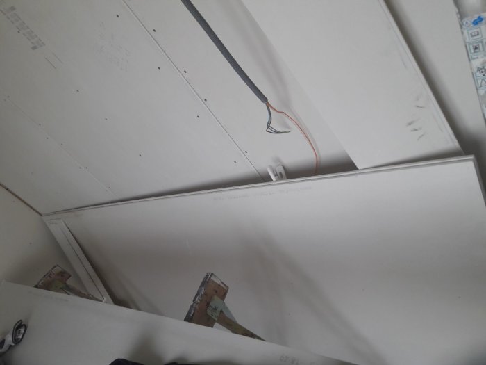 Två våtrumsskivor från Knauf staplade i ett hörn, märkta Humidboard 90x250.