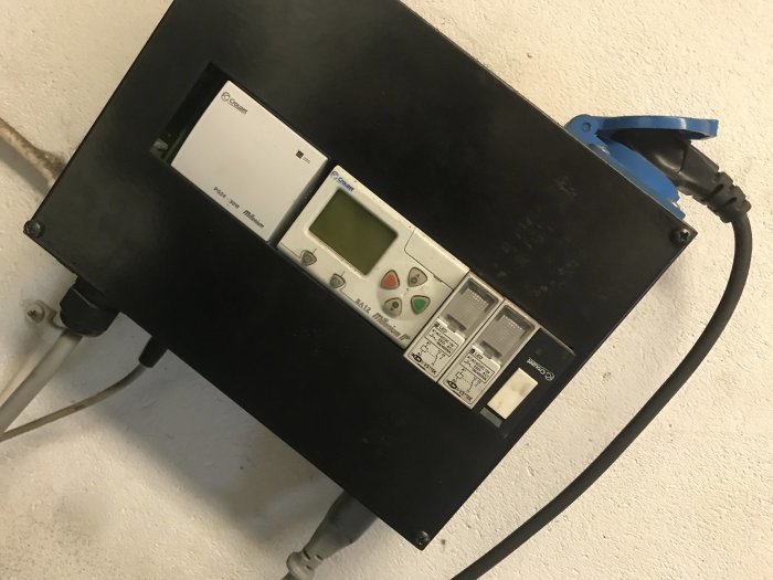 Elpanna monterad på vägg med inställningspanel och ansluten strömkabel.