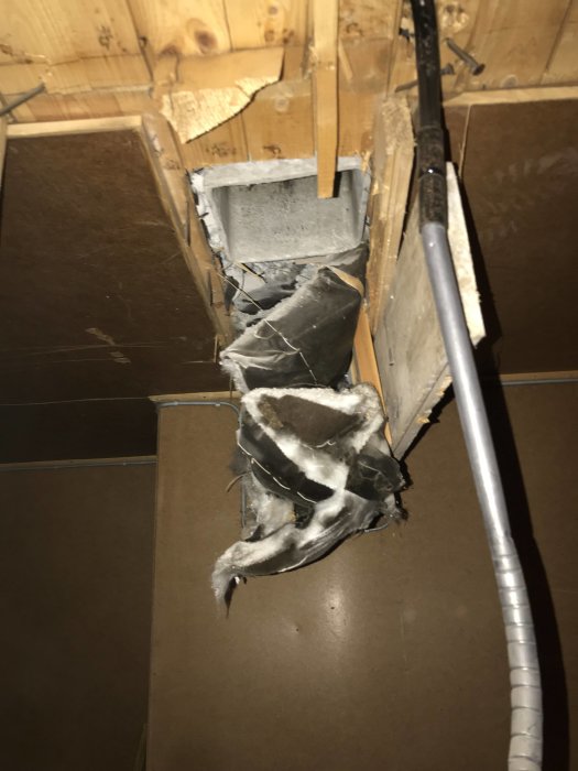 Gamla isoleringsmaterial runt en ventilationsschakt som kan misstänkas innehålla asbest.