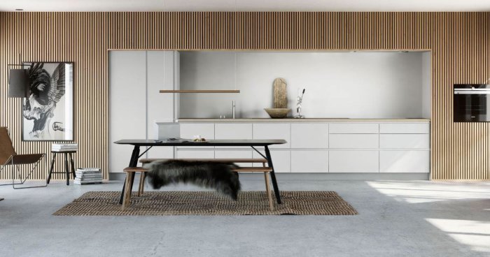 Modernt kök med vita skåp och träribbor på väggen med en fondvägg-effekt, inredningsdetaljer och matbord.