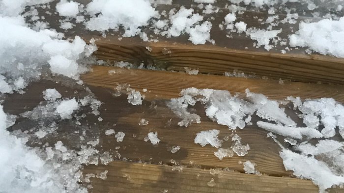 Nedsjunken träbrygga med snö och is på ytan som behöver förstärkas.