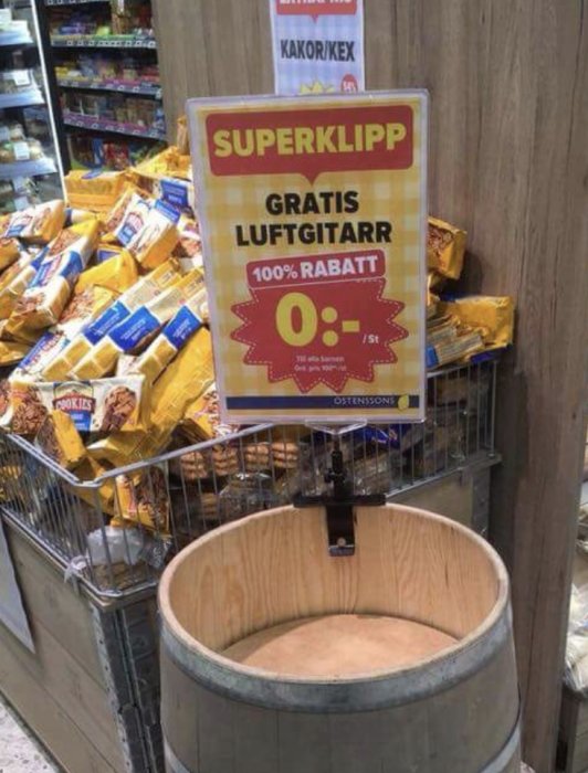 Skylt med texten "SUPERKLIPP GRATIS LUFTGITARR 100% RABATT" ovanför ett tomt fat i en livsmedelsbutik.