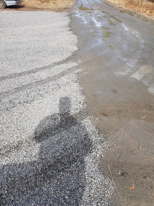 Grusväg möter asfalterad väg där gruset sprider sig ut på asfalten.
