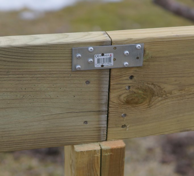 Första vangstycket i trä konstruerat med 45x95 stolpar och säkrat med ett metallbeslag.