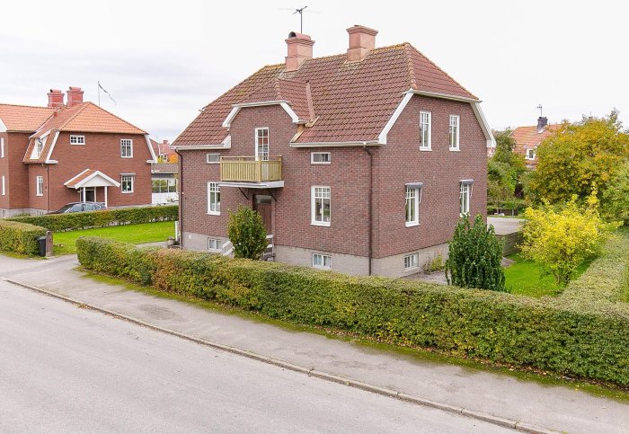 Tegelvilla från 1929 med två våningar och balkong, redo för renovering.